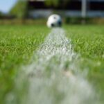 Verdedigers van een voetbalteam stappen gezamenlijk naar voren om de buitenspelval te zetten