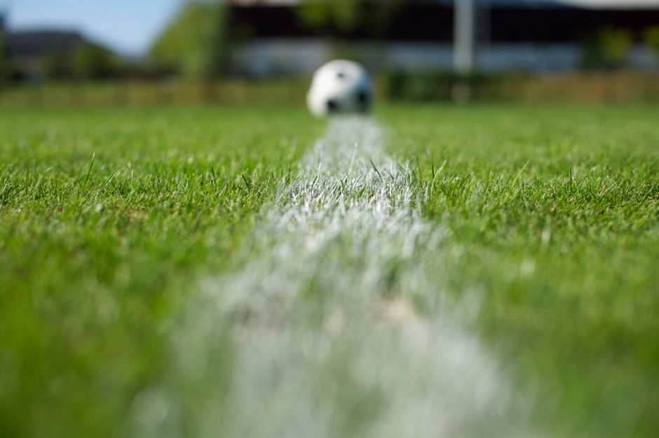Verdedigers van een voetbalteam stappen gezamenlijk naar voren om de buitenspelval te zetten