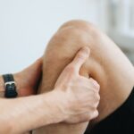 Fysiotherapeut behandelt de knie van een sporter op de behandeltafel
