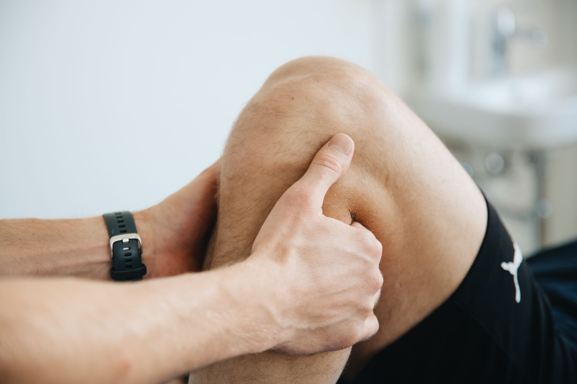 Fysiotherapeut behandelt de knie van een sporter op de behandeltafel