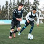 Voetballers spelen een rondo in een vierkant vak op het trainingsveld